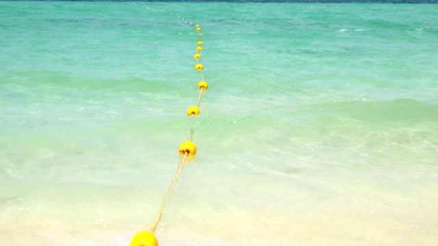 Yellow buoy with wave on the beach