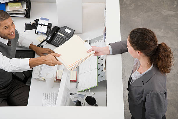 Man passing file to colleague