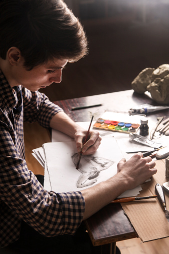 Young male artist sketching in his studio