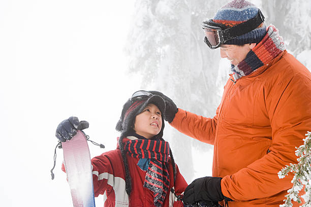 vater und sohn mit ski - father directly below child looking up stock-fotos und bilder