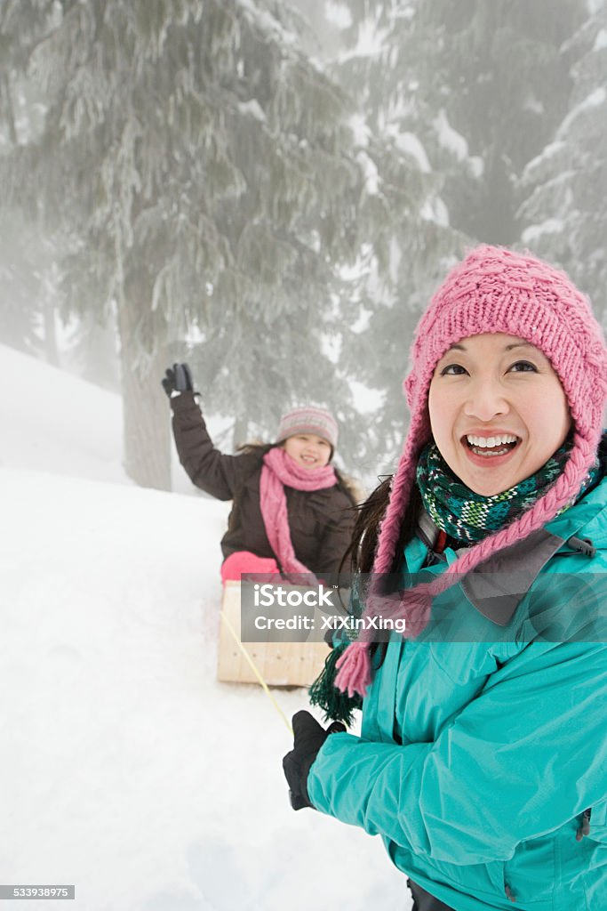 Madre e hija con un tobogán - Foto de stock de Vacaciones en la nieve libre de derechos