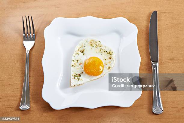 Fried Eggs In Heart Shape On White Plate And Cutlery Stock Photo - Download Image Now