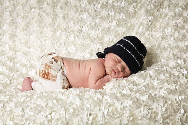 istock Newborn Baby sleeping wearing a black cap 533959787