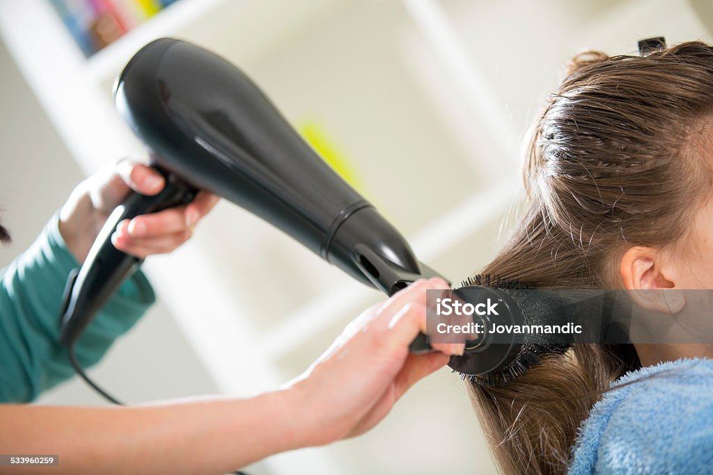 Hair drying. Drying long brown hair with hair dryer and round brush. 2015 Stock Photo