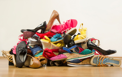 Untidy stack of shoes thrown on the ground.