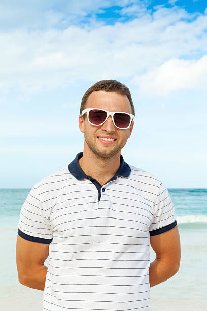 istock Young smiling man standing on summer sea coast 533963263