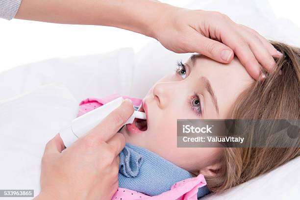 Little Girl With Sore Throat Using Spray Stock Photo - Download Image Now - 2015, Bed - Furniture, Care