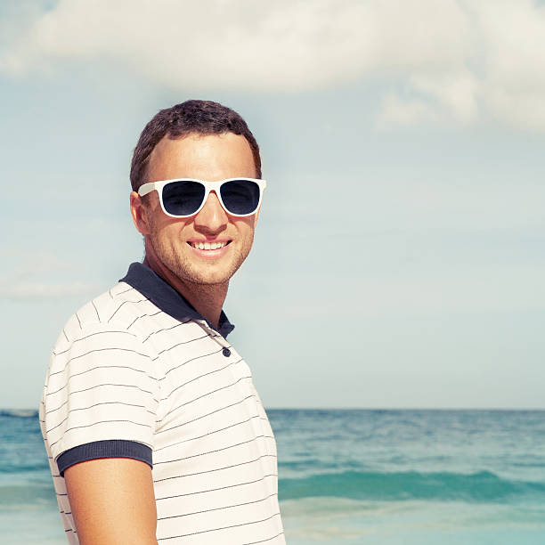 istock Young man standing with sunglasses on sea coast 533965533