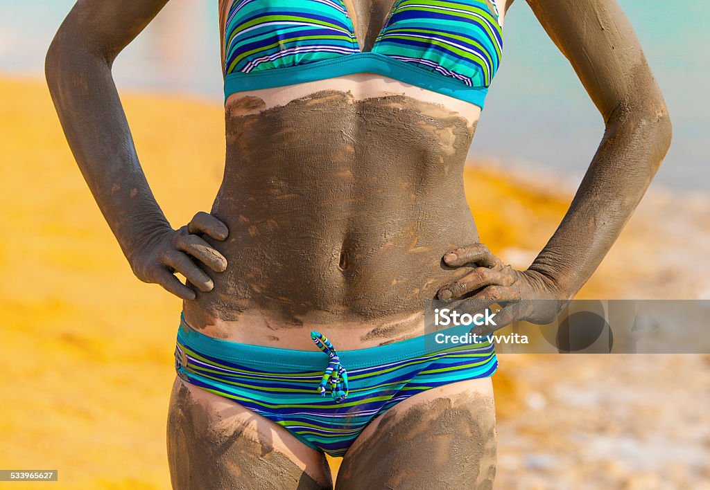 Young pretty woman smeared with mud on the beach 2015 Stock Photo