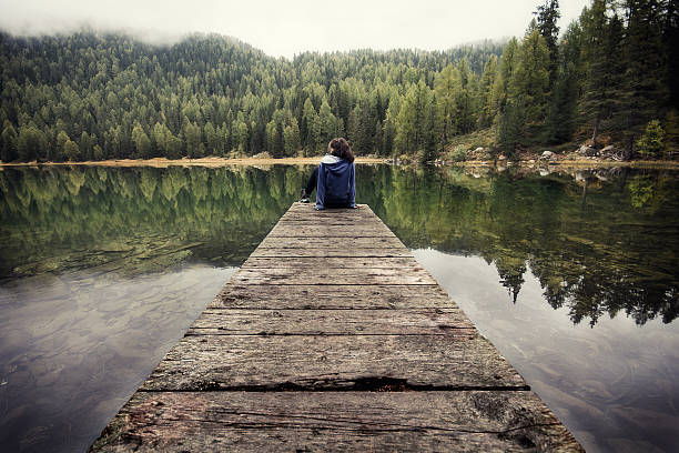 istock lonely girl on a pier 533966915