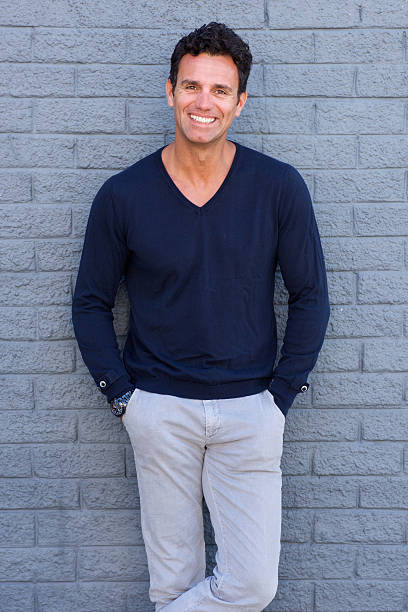 istock Confident man smiling against gray wall 533975222