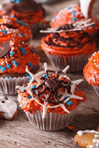 istock Beautiful orange Halloween cupcakes with spider close-up. vertical 533976556