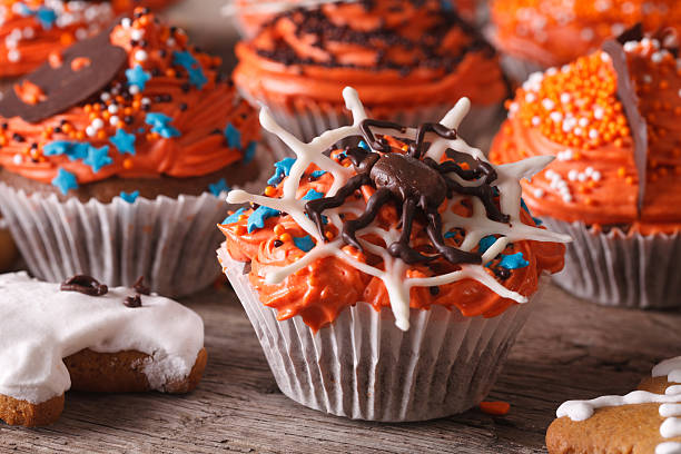 istock Beautiful orange Halloween cupcakes with spider close-up. Horizontal 533976848
