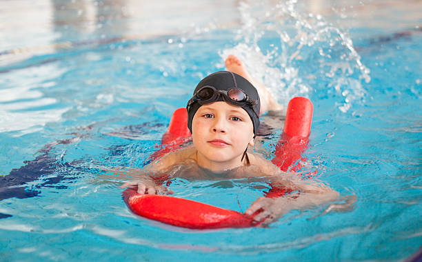 istock boy learn to swim with  red foam noodle in pool 533977742