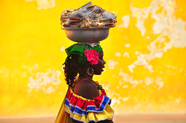 Colombian woman in Cartagena de Indias Cartagena de Indias, Colombia - June 15, 2014: Colombian woman in Cartagena de Indias with the traditional dress. In Colombia is usual to transport fresh fruit on the head. cartagena colombia stock pictures, royalty-free photos & images