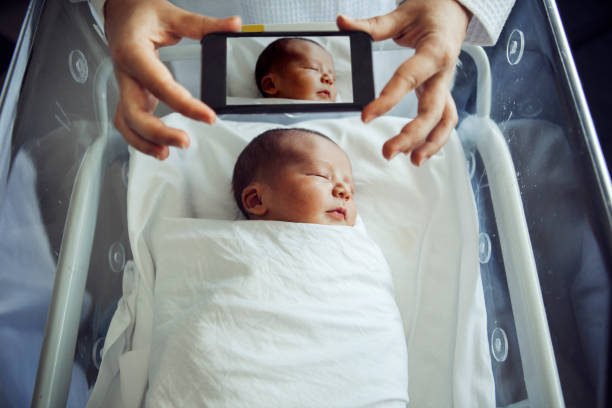 istock Mother photographing newborn son 533989720