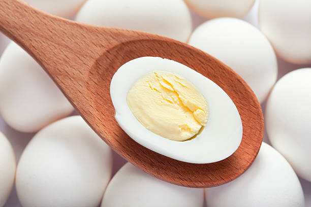 istock Half of boiled egg in wooden spoon on eggs 533991750