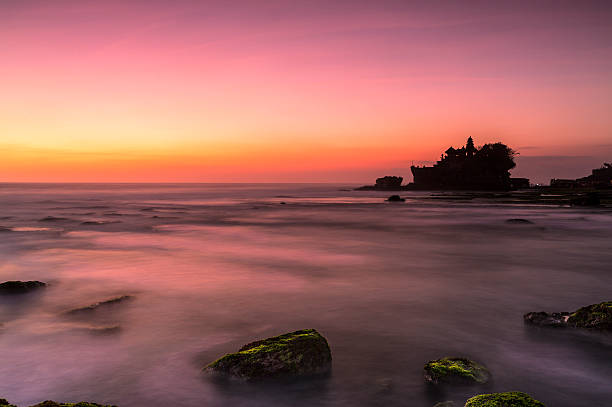 Famous Tanah Lot temple in Bali Indonesia Famous Tanah Lot temple in Bali at dusk time. tanah lot sunset stock pictures, royalty-free photos & images