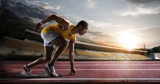 sport. sprinter verlässt startblöcke auf der laufstrecke. - athlet stock-fotos und bilder