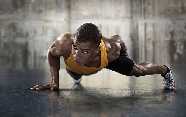 sportu. młody sportowe człowiek robi pompki. - exercising men push ups muscular build zdjęcia i obrazy z banku zdjęć