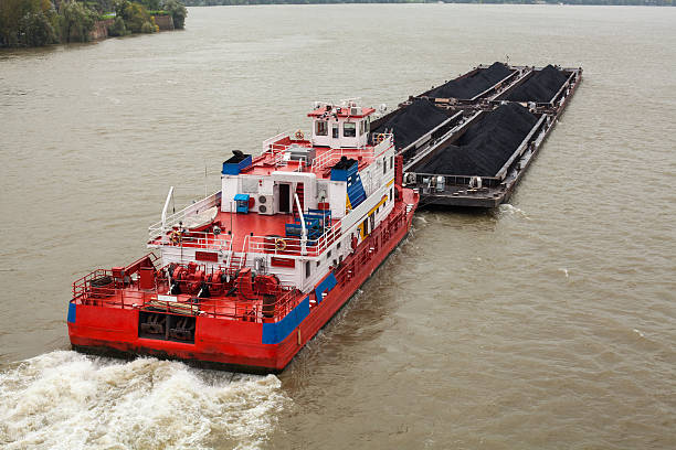 Tugboat Pushing a Heavy Barge Top view of Tugboat pushing a heavy barge on the river barge stock pictures, royalty-free photos & images