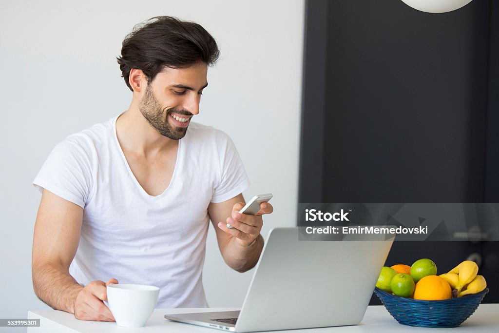 Morning news Young man checking morning news at home. Drinking coffee Breakfast Stock Photo