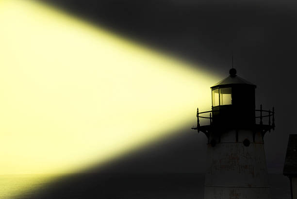 light house éclatante de jaune faisceau de lumière dans la nuit. - direction sea lighthouse landscape photos et images de collection