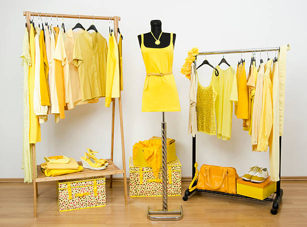 istock Dressing closet with yellow clothes arranged on hangers. 533996729