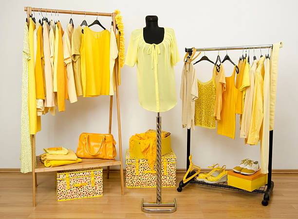 istock Dressing closet with yellow clothes arranged on hangers. 533996733