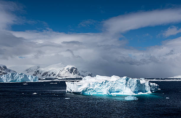 Icebergs floating in Antarctica Icebergs floating in Antarctica with ice covered mountains and glaciers in the backgrond dramatic landscape photos stock pictures, royalty-free photos & images