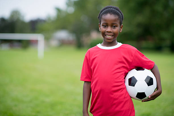 istock An elementary age girl is standing with a soccer ball 533998796