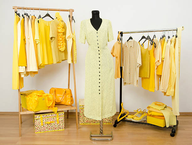istock Dressing closet with yellow clothes arranged on hangers. 533999501