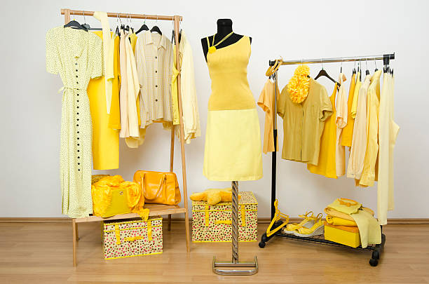 istock Dressing closet with yellow clothes arranged on hangers. 533999503
