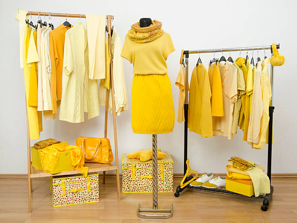 istock Dressing closet with yellow clothes arranged on hangers. 533999507