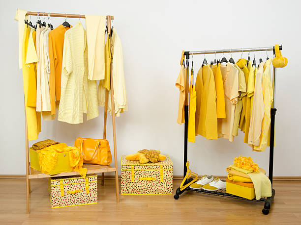 istock Dressing closet with yellow clothes arranged on hangers. 533999515