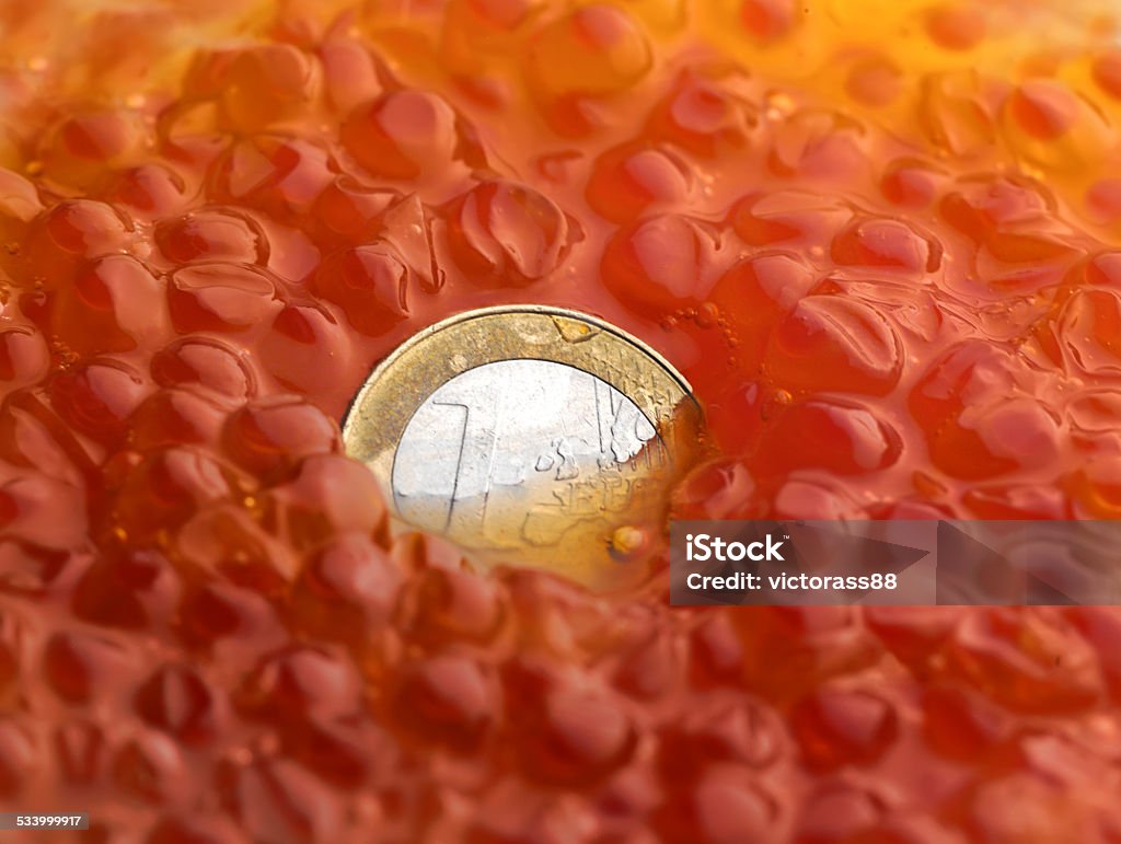 Coin in Caviar Macro shot of euro cent sinking in red caviar, business metaphor 2015 Stock Photo