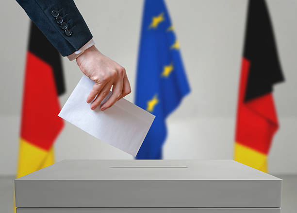 istock Election in Germany. Voter holds envelope above vote ballot. 534000396