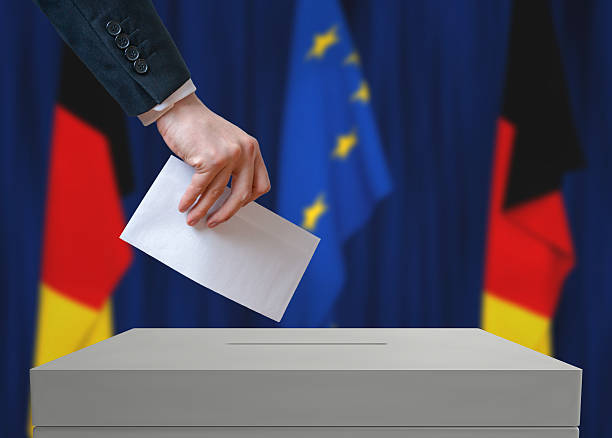 istock Election in Germany. Voter holds envelope above vote ballot. 534000512