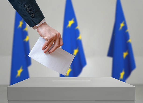 istock EU (European Union) election. Voter holds envelope above vote ballot. 534000616