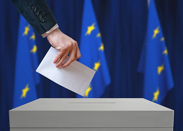istock EU (European Union) election. Voter holds envelope above vote ballot. 534000734