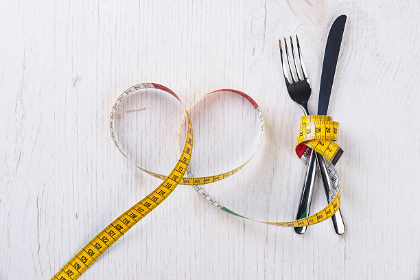 istock Fork and knife tied with metering tape 534000976