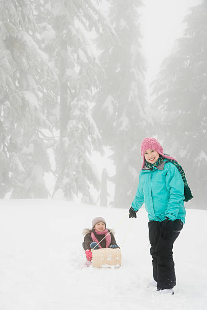 istock Mother and daughter with toboggan 534001069