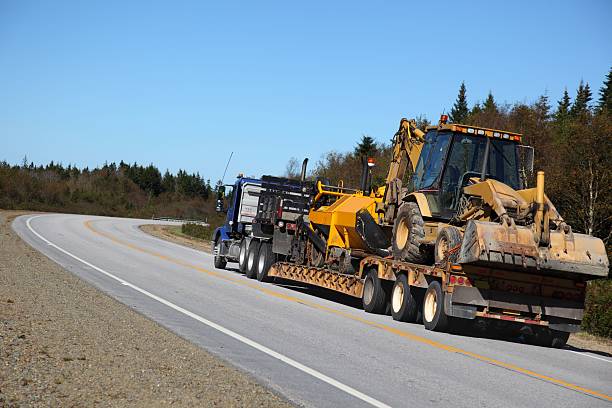 istock Semi truck with a paving equipment aboard the trailer. 534001585