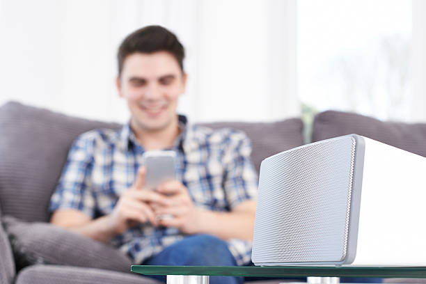 istock Man Streams Music From Mobile Phone To Wireless Speaker 534001620