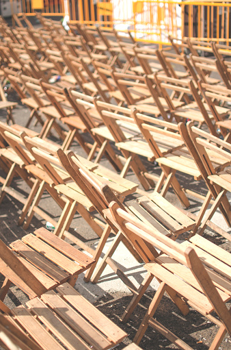 several rows of empty wooden chairs and some guardtrails