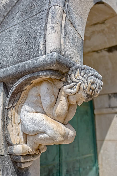 Angel statue door decoration Angel statue decoration above the entrance door of the mausoleum on the old catholic cemetery. old catholic church on island brac croatia stock pictures, royalty-free photos & images