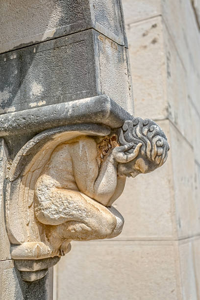 Angel statue door decoration Angel statue decoration above the entrance door of the mausoleum on the old catholic cemetery. old catholic church on island brac croatia stock pictures, royalty-free photos & images