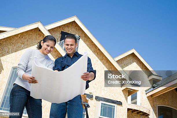 Couple Looking At A Blueprint Stock Photo - Download Image Now - Construction Industry, Moving House, Home Ownership