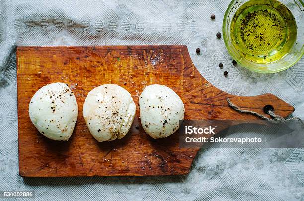 Mozzarella Balls On Old Wooden Board With Olive Oil Stock Photo - Download Image Now