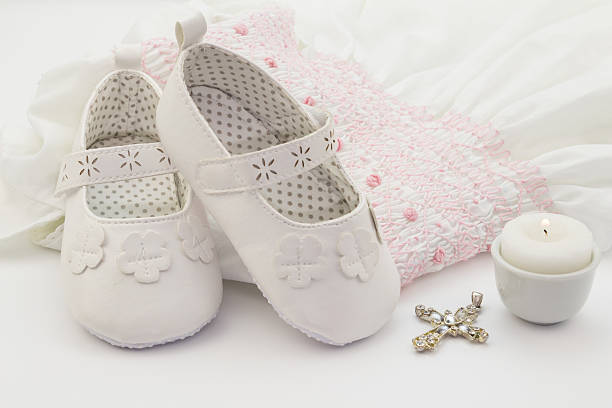 paar weiß-babyschuhe mit gestickten taufe weißen kleid - embroidery needlecraft product dress pattern stock-fotos und bilder